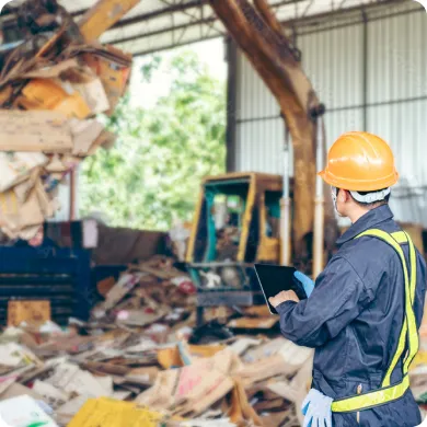 Maquinaria manipulando residuos en una planta de reciclaje.